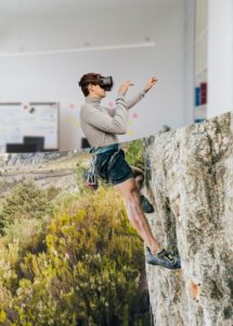 Hombre practicando escalada deportiva en roca a través de unas gafas de realidad virtual